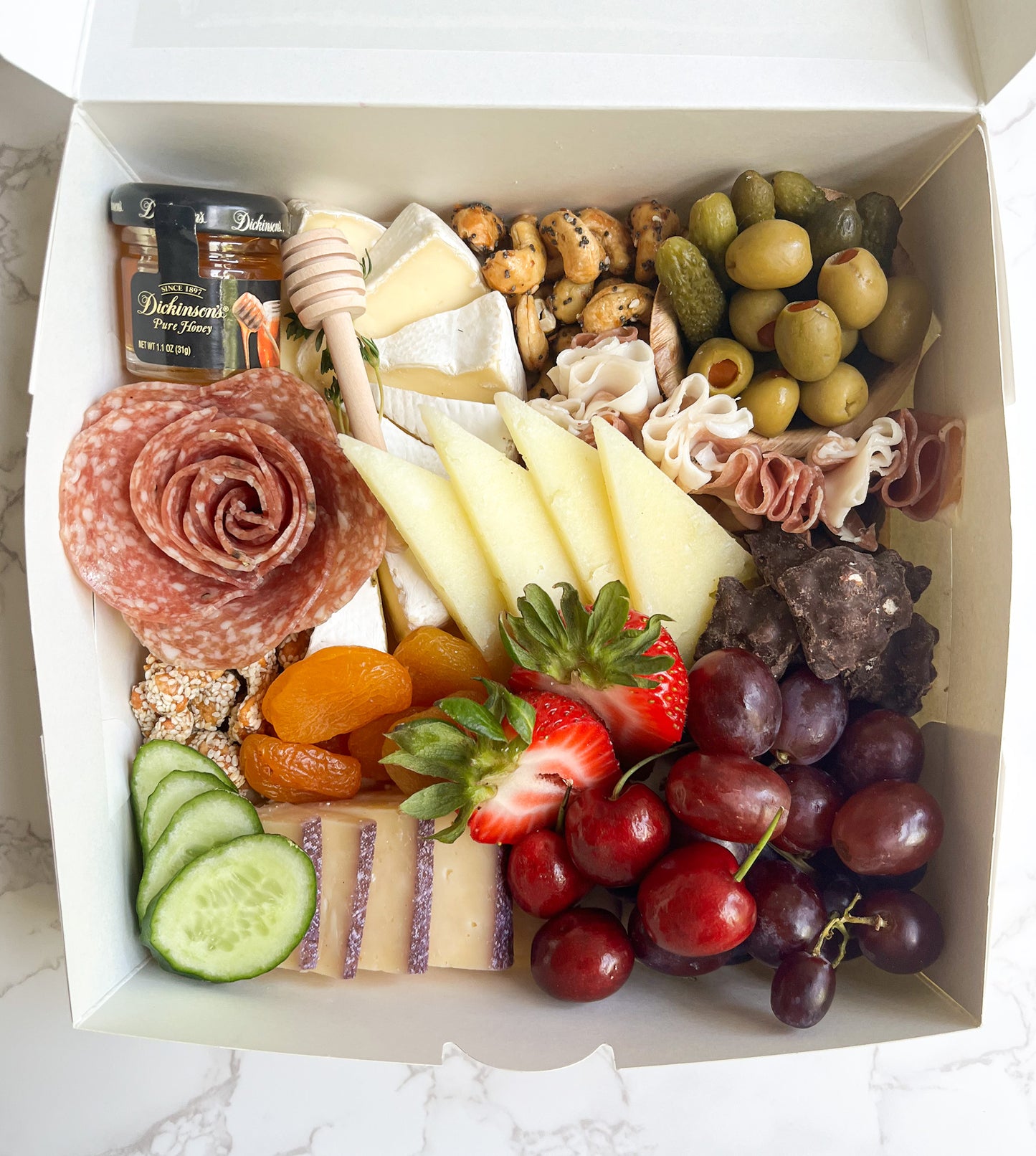 The Picnic Box is the perfect portable charcuterie box featuring gourmet cheeses, cured meats (salami and prosciutto), and gourmet accompaniments (nuts, dried fruit, olives, pickles, chocolates, and more)! The platter is artfully arranged creating an elegant grazing experience. Sacramento charcuterie catering is available. Whether it's for a party, wedding, or corporate event, you can't go wrong!