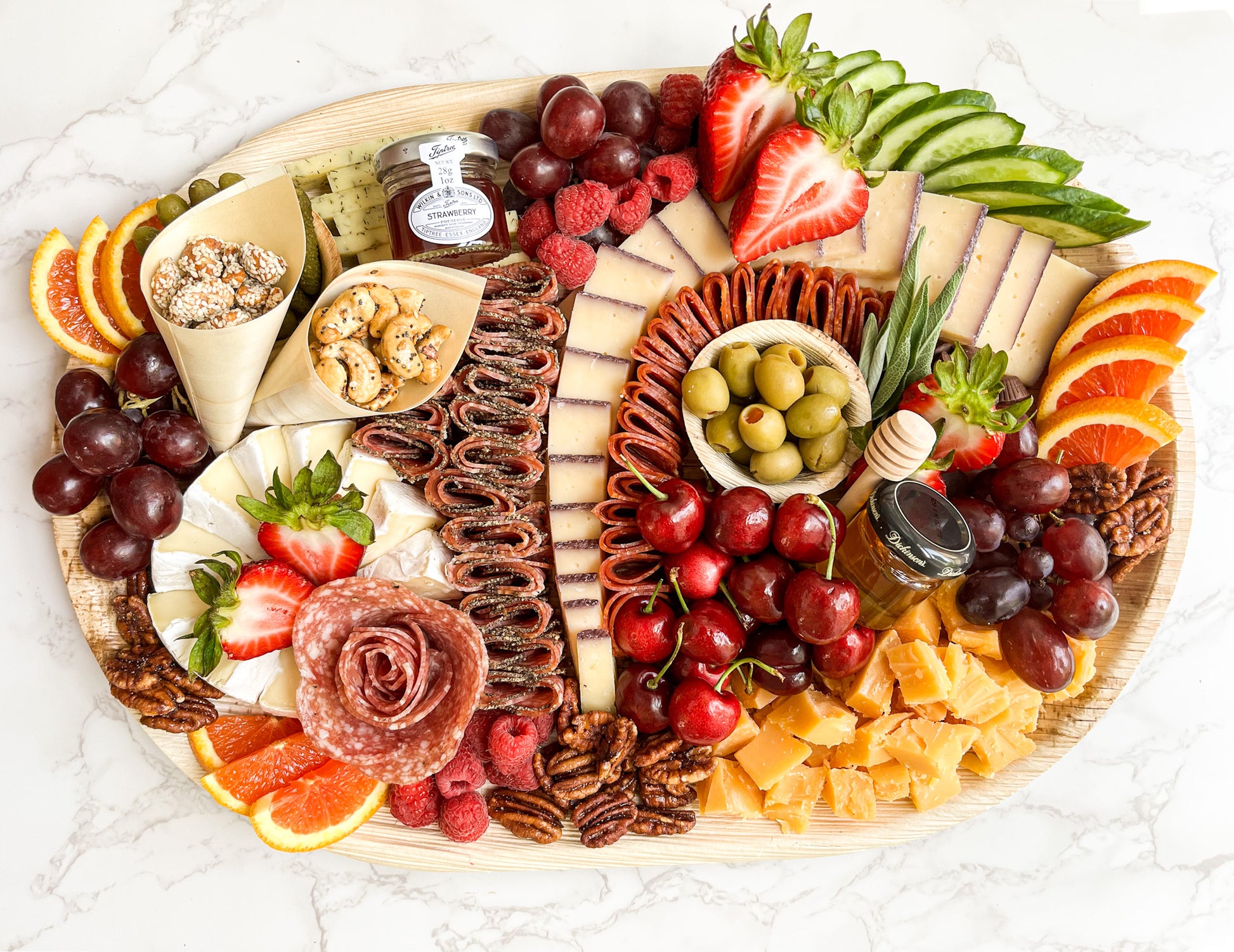 Large charcuterie platter featuring gourmet cheeses, cured meats (salami variety), and gourmet accompaniments (nuts, fruit, olives, pickles, and more)! The platter is artfully arranged creating an elegant grazing experience. Sacramento charcuterie catering is available. Whether it's for a party, wedding, or corporate event, you can't go wrong! 